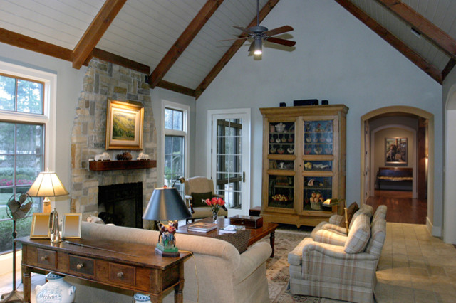 Mittelgroßes, Offenes Klassisches Wohnzimmer ohne Kamin mit grauer Wandfarbe, braunem Holzboden und Kaminumrandung aus Stein in Houston