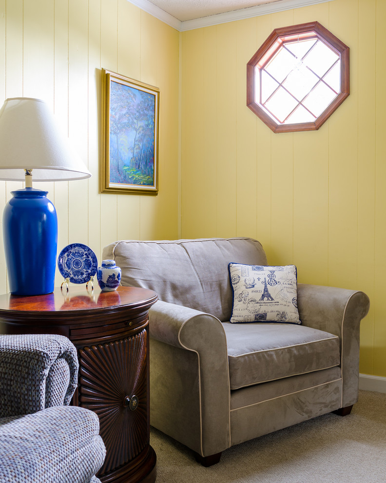 Exemple d'un salon chic de taille moyenne et fermé avec un mur jaune, moquette, une salle de réception, aucun téléviseur, un sol beige, une cheminée standard et un manteau de cheminée en brique.