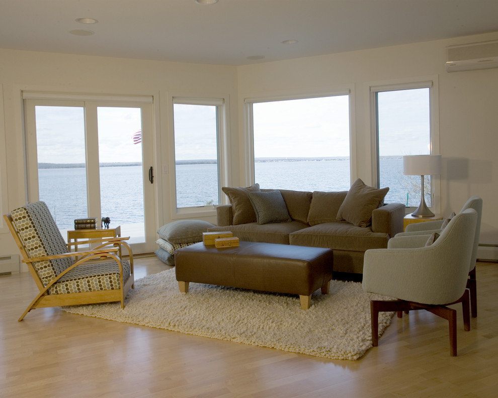 Ejemplo de salón abierto actual de tamaño medio sin chimenea y televisor con paredes blancas, suelo de madera clara y suelo beige