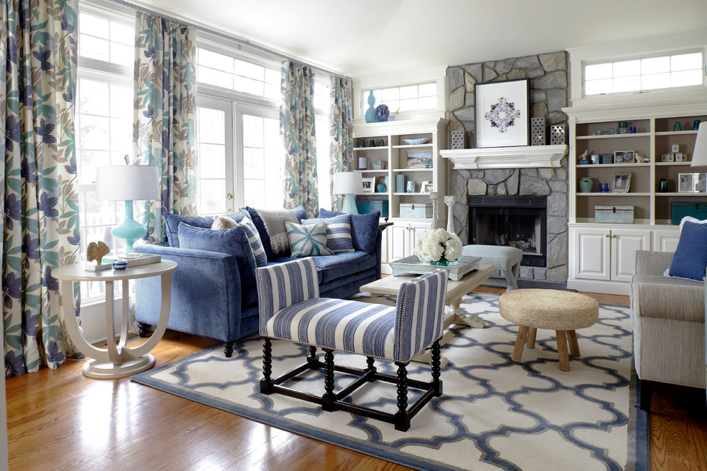 Beach style formal living room in New York with white walls, medium hardwood flooring, a standard fireplace and a stone fireplace surround.