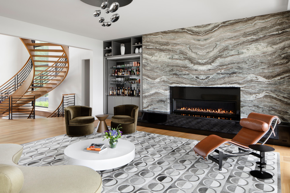 Пример оригинального дизайна: огромная открытая гостиная комната в стиле модернизм с домашним баром, белыми стенами, светлым паркетным полом, горизонтальным камином, фасадом камина из камня и коричневым полом без телевизора