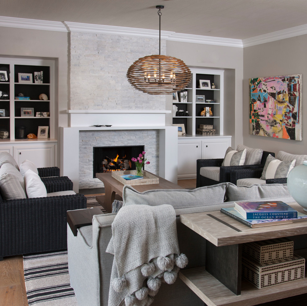 Источник вдохновения для домашнего уюта: гостиная комната в стиле неоклассика (современная классика) с серыми стенами, паркетным полом среднего тона, стандартным камином, фасадом камина из камня и коричневым полом