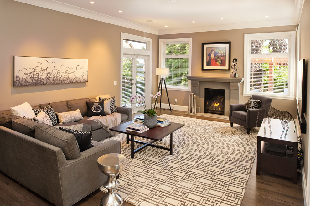 Example of a mid-sized transitional enclosed dark wood floor living room design in Vancouver with beige walls and a standard fireplace