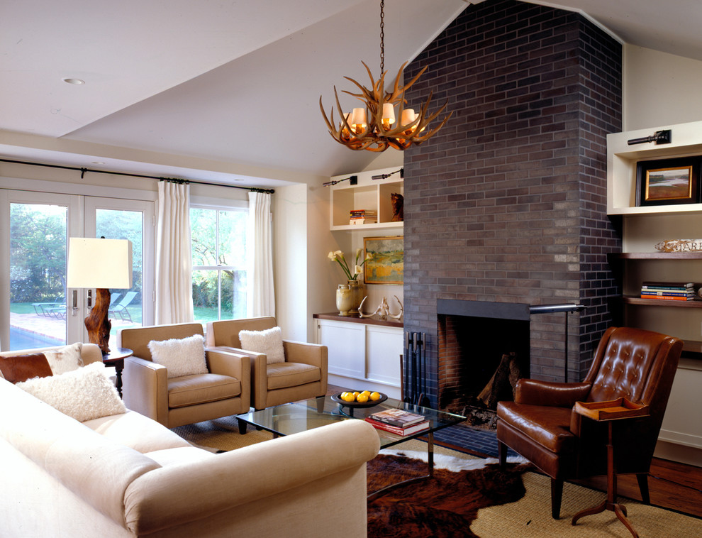 Стильный дизайн: гостиная комната в стиле кантри с фасадом камина из кирпича и ковром на полу - последний тренд