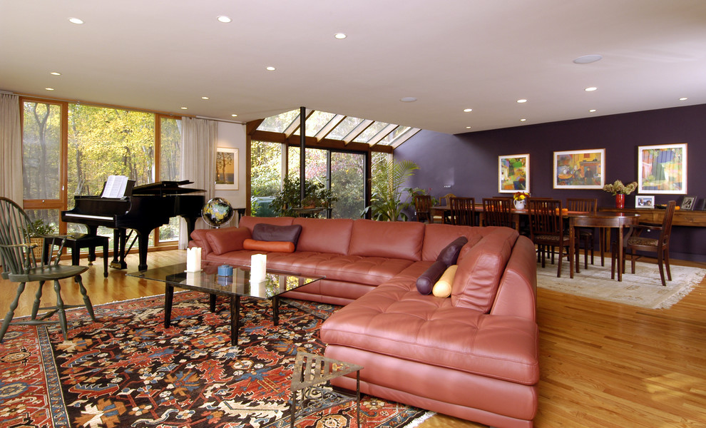 Idee per un soggiorno contemporaneo aperto con sala della musica, pavimento in legno massello medio, pareti viola e tappeto