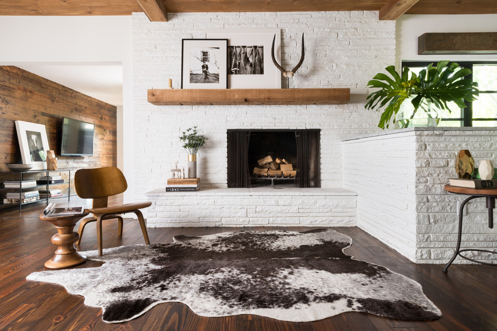 Offenes Skandinavisches Wohnzimmer mit weißer Wandfarbe, dunklem Holzboden, Kamin und Kaminumrandung aus Stein in Seattle