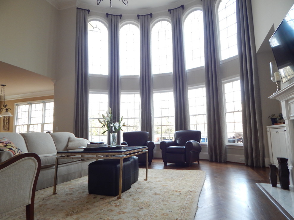 Источник вдохновения для домашнего уюта: большая двухуровневая гостиная комната в классическом стиле с серыми стенами, темным паркетным полом, стандартным камином, фасадом камина из камня и телевизором на стене