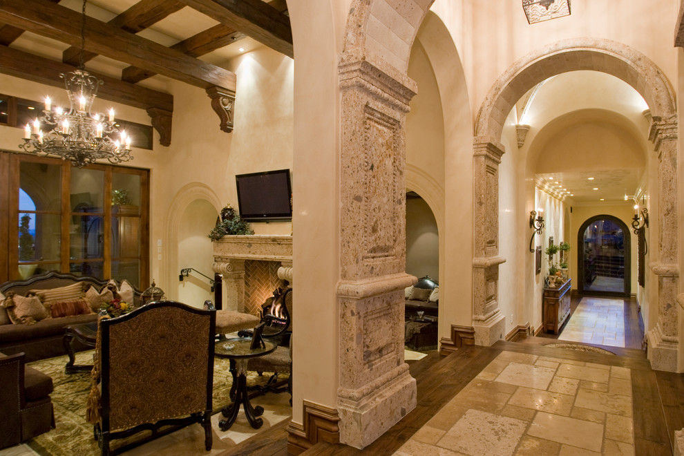 Foto di un ampio soggiorno chic aperto con sala formale, pareti beige, pavimento in legno massello medio, camino classico e cornice del camino in pietra