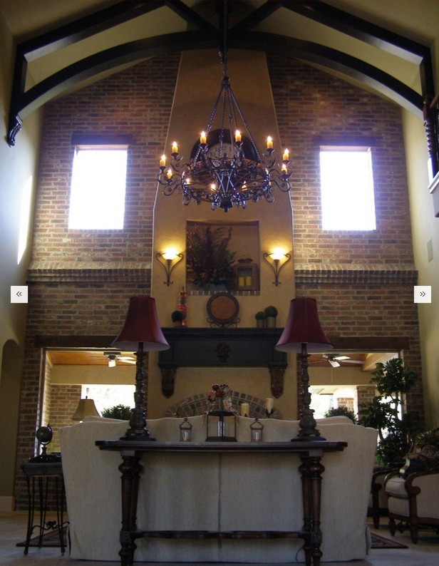 Ejemplo de salón abierto actual extra grande con paredes beige, suelo de piedra caliza y marco de chimenea de yeso