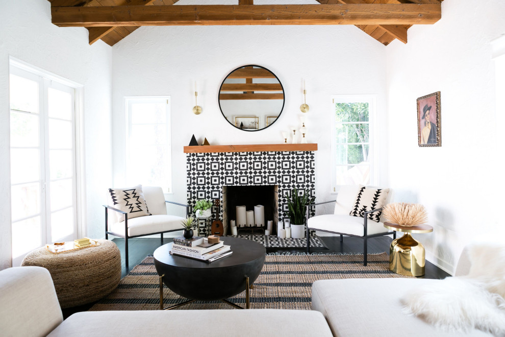 Repräsentatives, Fernseherloses Mediterranes Wohnzimmer mit weißer Wandfarbe, Kamin, gefliester Kaminumrandung, freigelegten Dachbalken und gewölbter Decke in Los Angeles