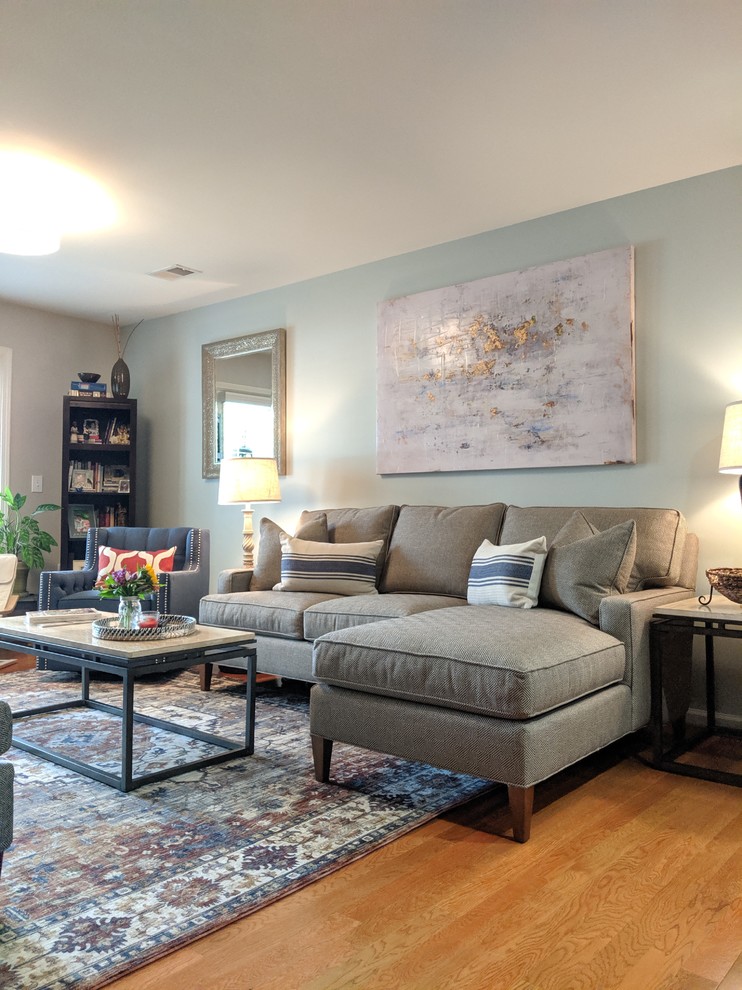 Foto di un piccolo soggiorno tradizionale chiuso con pareti blu, pavimento in legno massello medio, TV a parete e pavimento marrone