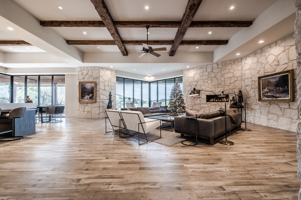 Photo of a large contemporary formal open plan living room in Austin with beige walls, no tv, medium hardwood flooring, brown floors, a ribbon fireplace and a stone fireplace surround.