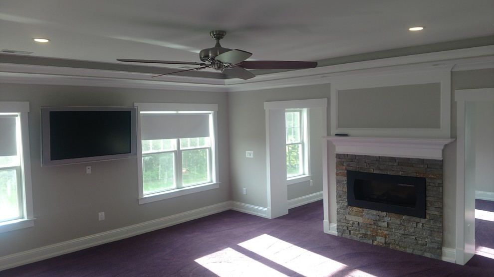 ワシントンD.C.にある広いカントリー風のおしゃれなLDK (グレーの壁、カーペット敷き、横長型暖炉、石材の暖炉まわり、壁掛け型テレビ、紫の床) の写真