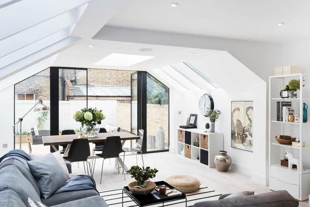 Danish light wood floor living room photo in London with white walls