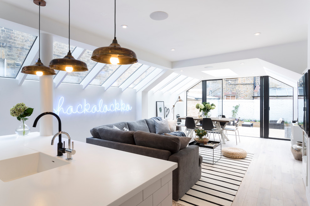Photo of a scandinavian living room in London with white walls and light hardwood flooring.