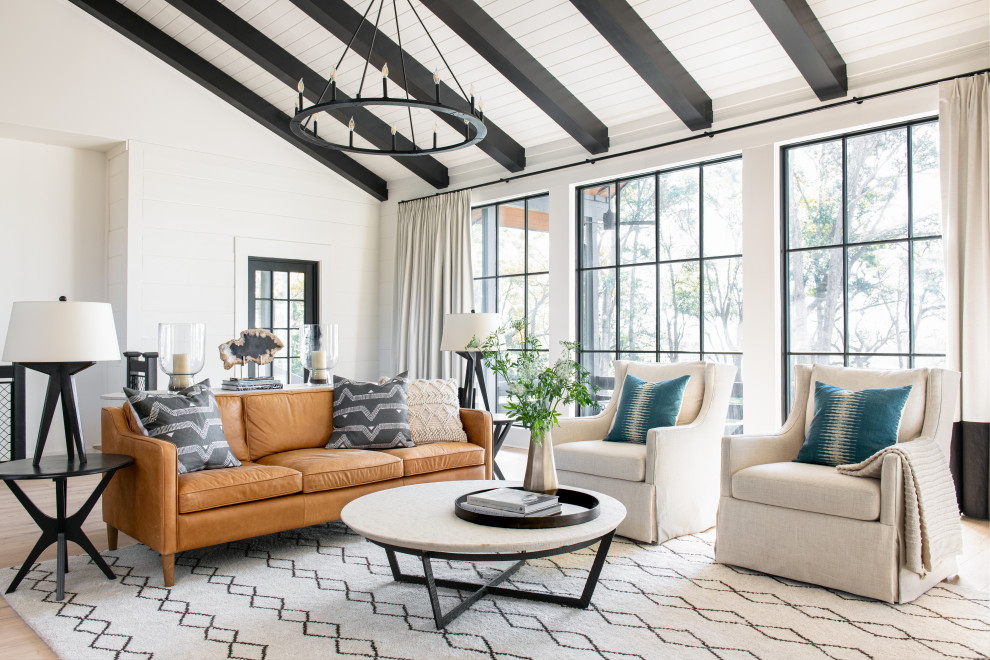 Immagine di un soggiorno country con pareti bianche, parquet chiaro, soffitto a volta e pareti in perlinato