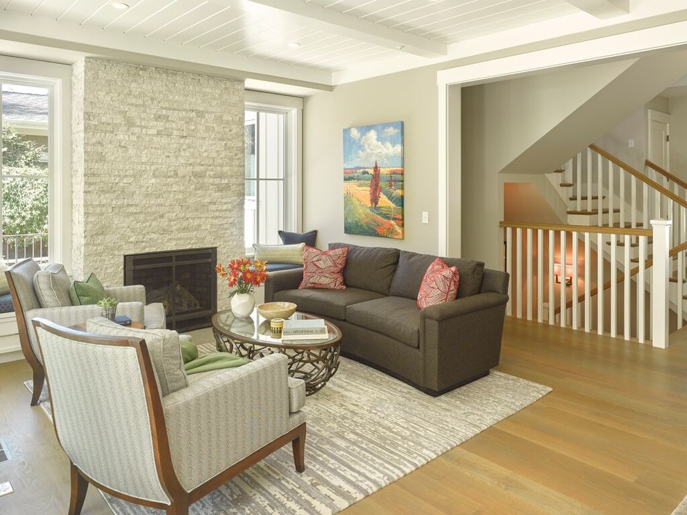 Пример оригинального дизайна: открытая гостиная комната в стиле кантри с серыми стенами, светлым паркетным полом, стандартным камином и фасадом камина из камня