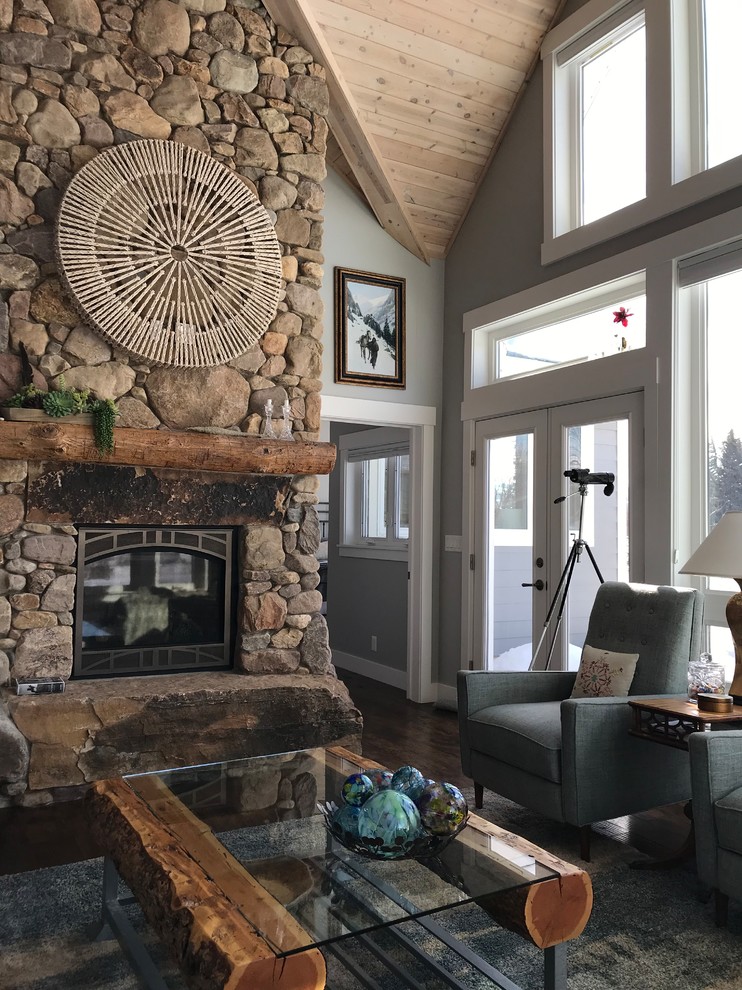 Inspiration for a medium sized country open plan living room in Salt Lake City with grey walls, dark hardwood flooring, a standard fireplace, a stone fireplace surround, no tv and brown floors.