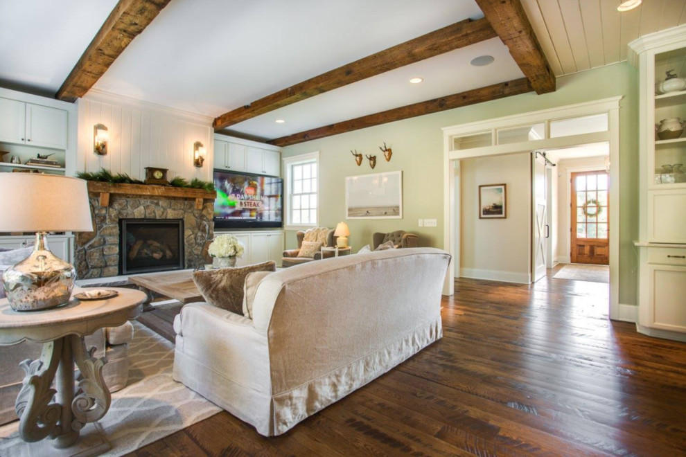 This is an example of a large rural formal open plan living room in Minneapolis with green walls, dark hardwood flooring, a standard fireplace, a stone fireplace surround and no tv.