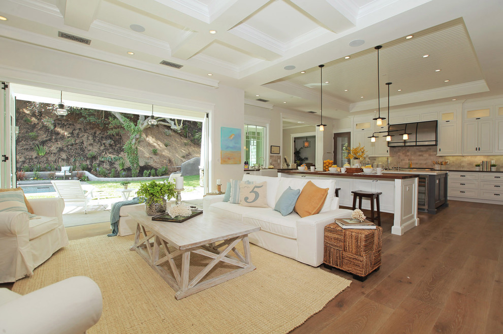 Foto di un ampio soggiorno country aperto con pareti bianche, pavimento in legno massello medio e pavimento marrone