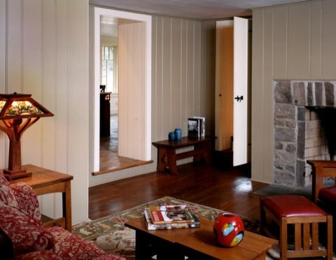 Modelo de salón para visitas cerrado de estilo de casa de campo extra grande con suelo de madera en tonos medios, paredes beige, todas las chimeneas y marco de chimenea de piedra