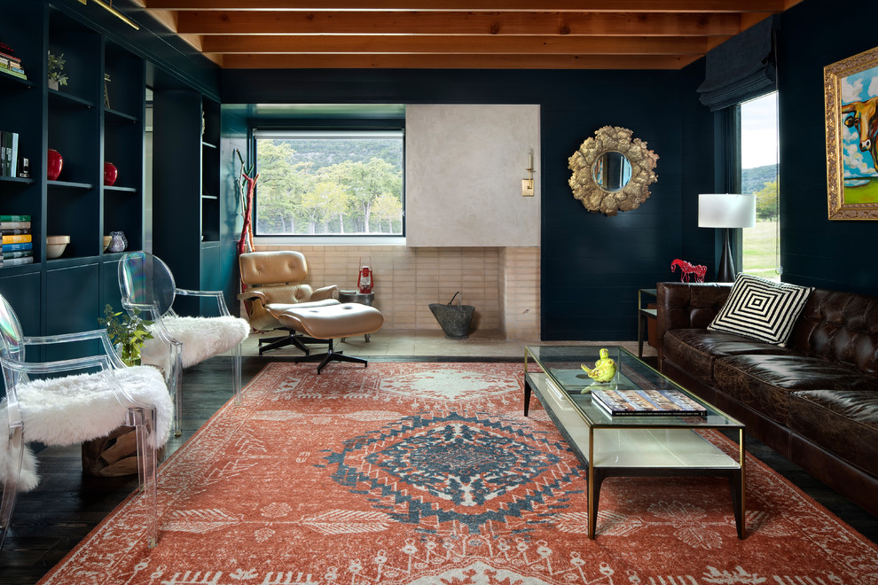 Réalisation d'un salon champêtre fermé avec un mur bleu, parquet foncé, une cheminée double-face, un manteau de cheminée en brique et un sol marron.
