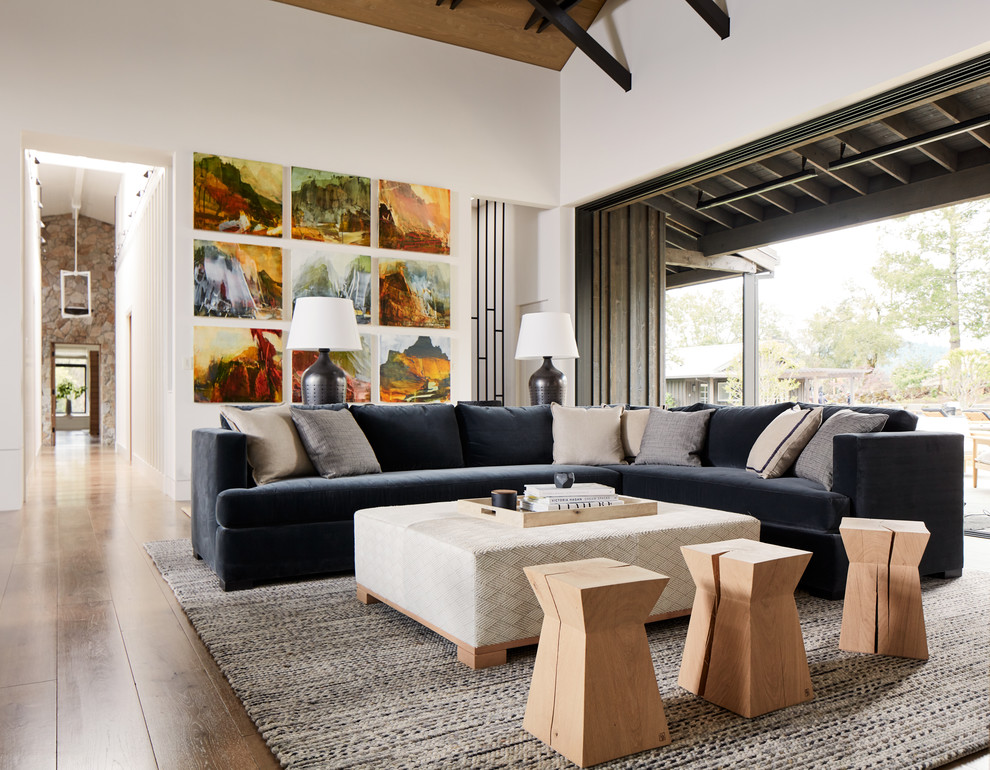 Foto di un soggiorno country con pareti bianche, pavimento in legno massello medio e tappeto