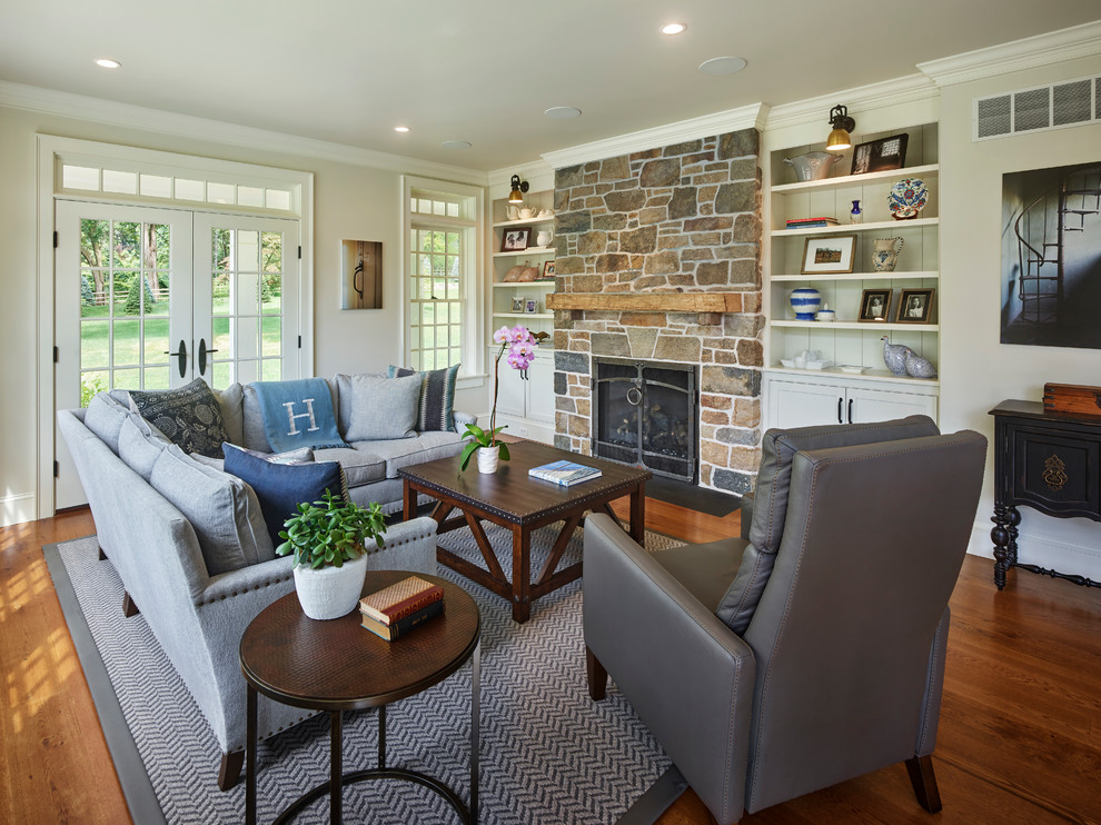 Rural living room in New York with beige walls, dark hardwood flooring, a standard fireplace and brown floors.