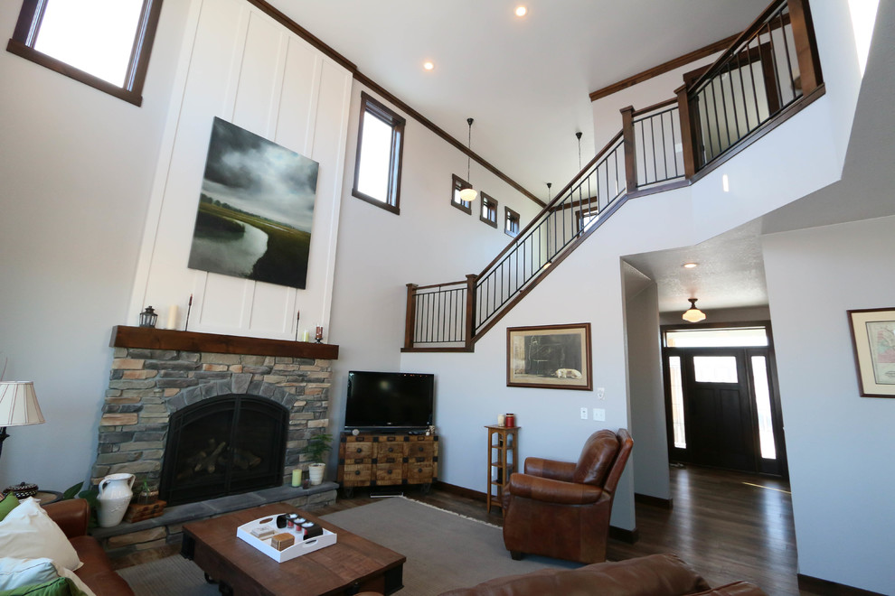Exemple d'un salon nature de taille moyenne et ouvert avec un mur gris, une cheminée standard, un manteau de cheminée en pierre et un téléviseur indépendant.