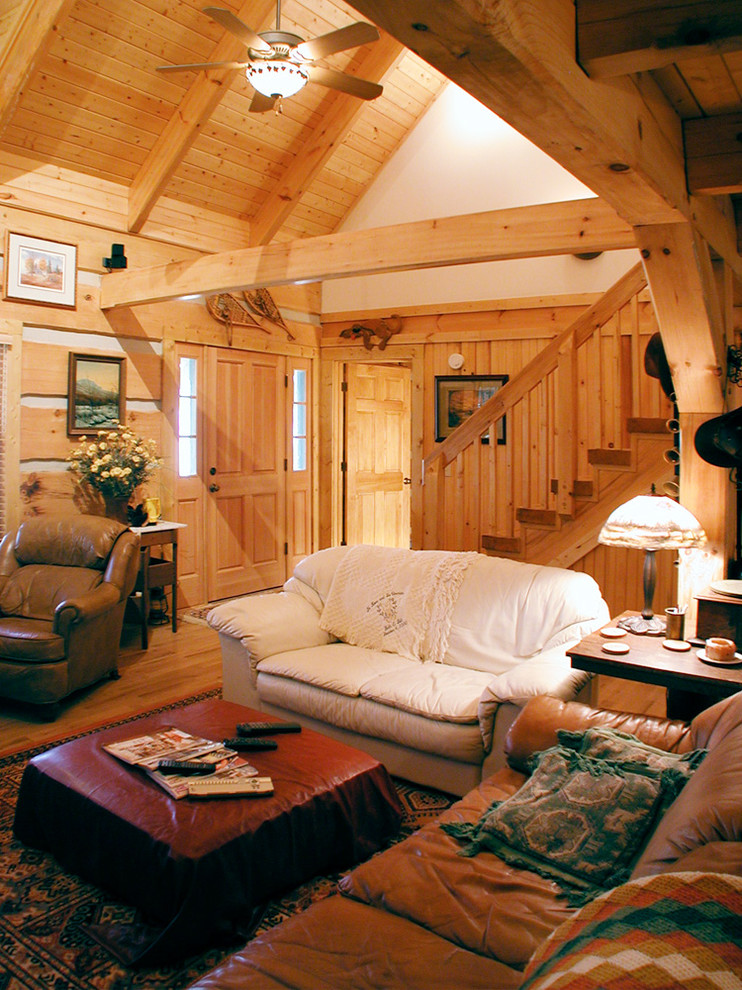 Diseño de salón abierto rural pequeño sin televisor con suelo de madera en tonos medios, todas las chimeneas y marco de chimenea de piedra