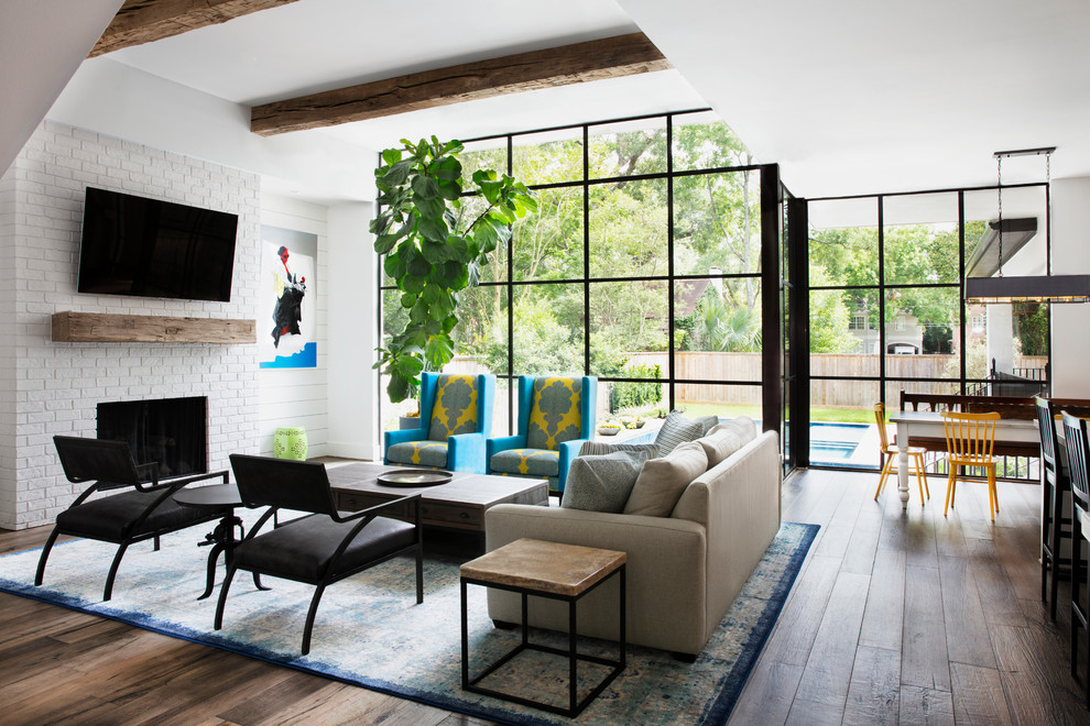 Photo of a large rural open plan living room in Houston with white walls, dark hardwood flooring, a standard fireplace, a brick fireplace surround, brown floors and a wall mounted tv.