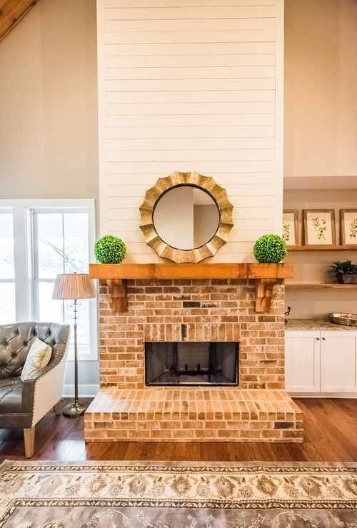 Inspiration for a large country formal and open concept medium tone wood floor and brown floor living room remodel in Atlanta with gray walls, a standard fireplace, a brick fireplace and no tv