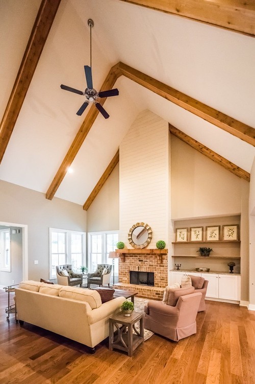 Inspiration for a large farmhouse formal and open concept medium tone wood floor and brown floor living room remodel in Atlanta with gray walls, a standard fireplace, a brick fireplace and no tv