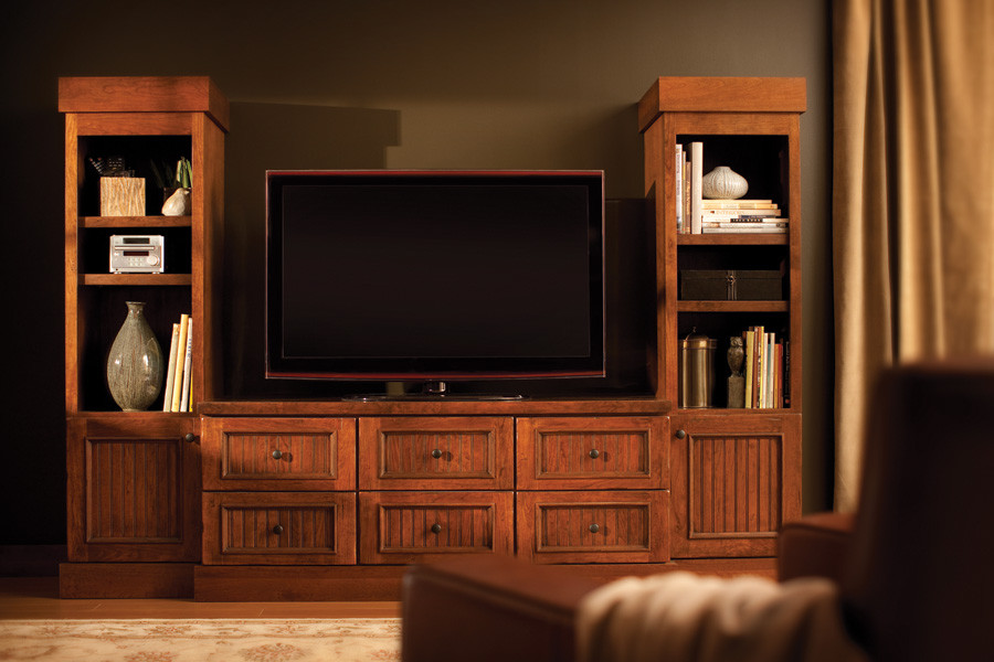 Modelo de salón para visitas cerrado de estilo americano de tamaño medio con paredes marrones, suelo de madera en tonos medios, televisor independiente y suelo marrón
