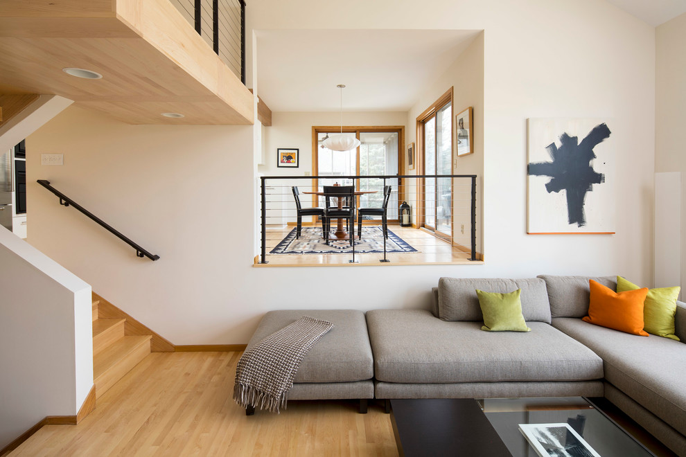 Ispirazione per un soggiorno design con pareti bianche, parquet chiaro e pavimento beige