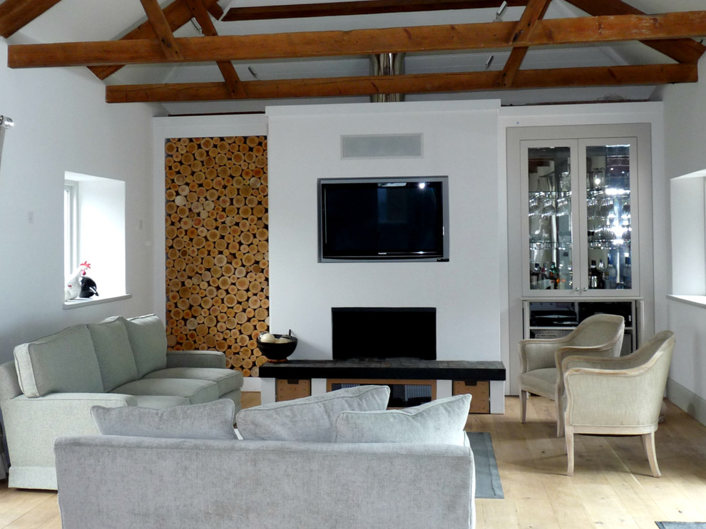Trendy light wood floor living room photo in Gloucestershire with white walls, a standard fireplace and a plaster fireplace