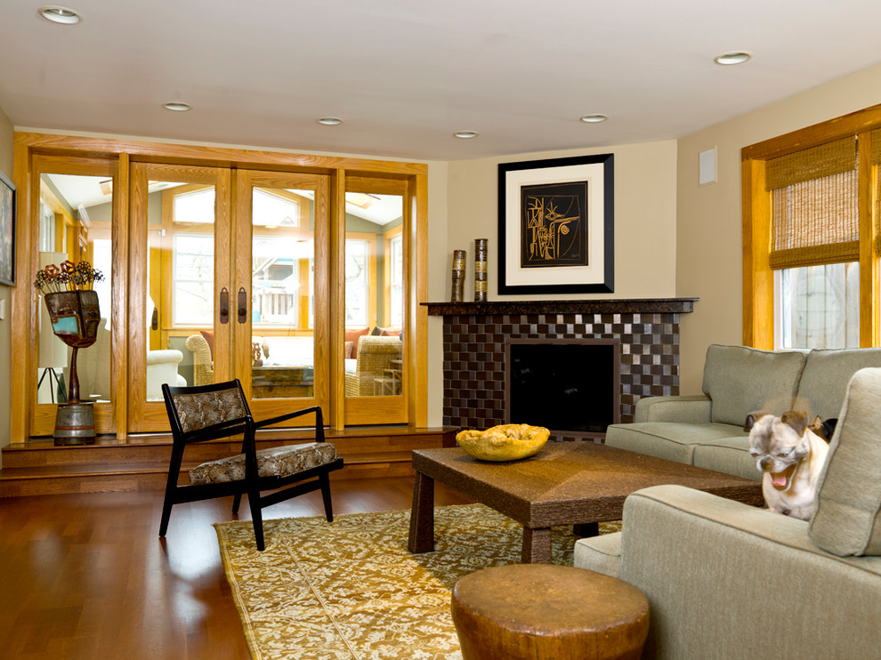 Immagine di un soggiorno minimal con pareti beige, pavimento in legno massello medio e camino ad angolo