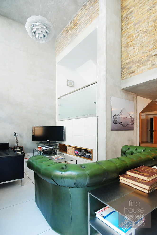 Inspiration for an expansive industrial mezzanine living room in Gloucestershire with a music area, grey walls, concrete flooring and a freestanding tv.