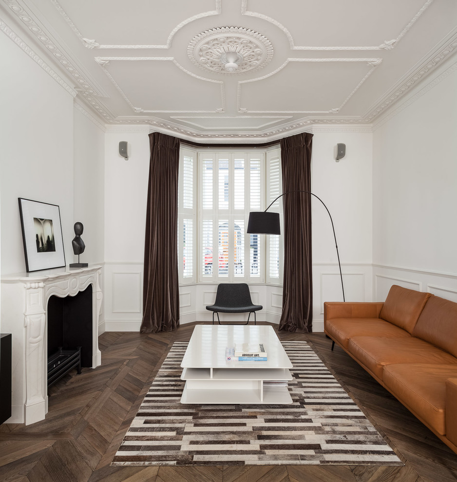 Пример оригинального дизайна: гостиная комната в современном стиле с белыми стенами и стандартным камином