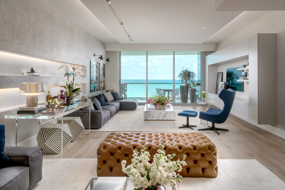 Offenes, Großes Modernes Wohnzimmer mit weißer Wandfarbe, hellem Holzboden, TV-Wand und beigem Boden in Miami