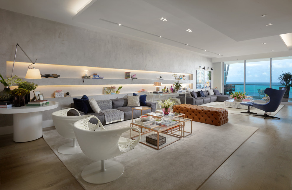 Стильный дизайн: большая открытая гостиная комната в современном стиле с светлым паркетным полом, бежевым полом, серыми стенами и телевизором на стене - последний тренд
