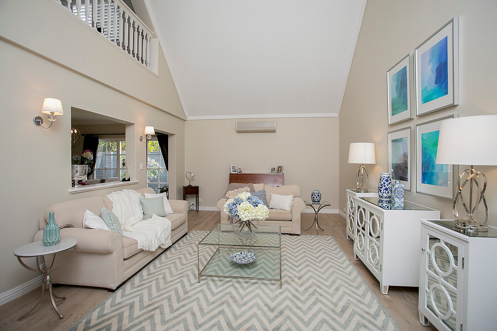 Medium sized beach style formal open plan living room in Perth with light hardwood flooring, a standard fireplace, a wooden fireplace surround and beige walls.