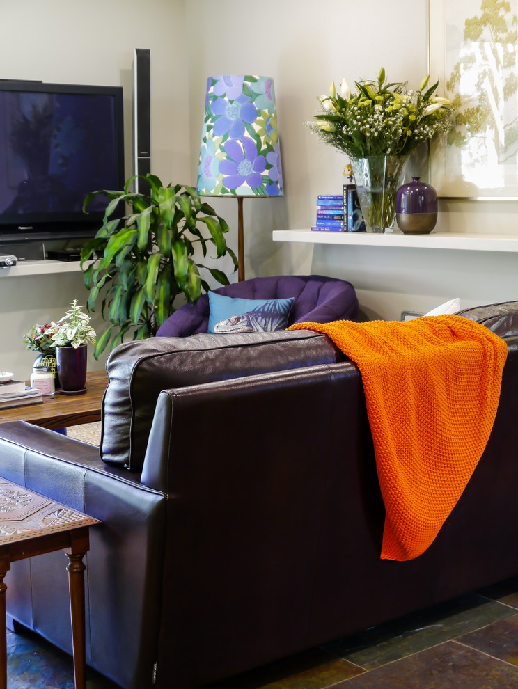 Immagine di un grande soggiorno eclettico aperto con pareti beige, pavimento in ardesia, TV a parete e pavimento multicolore
