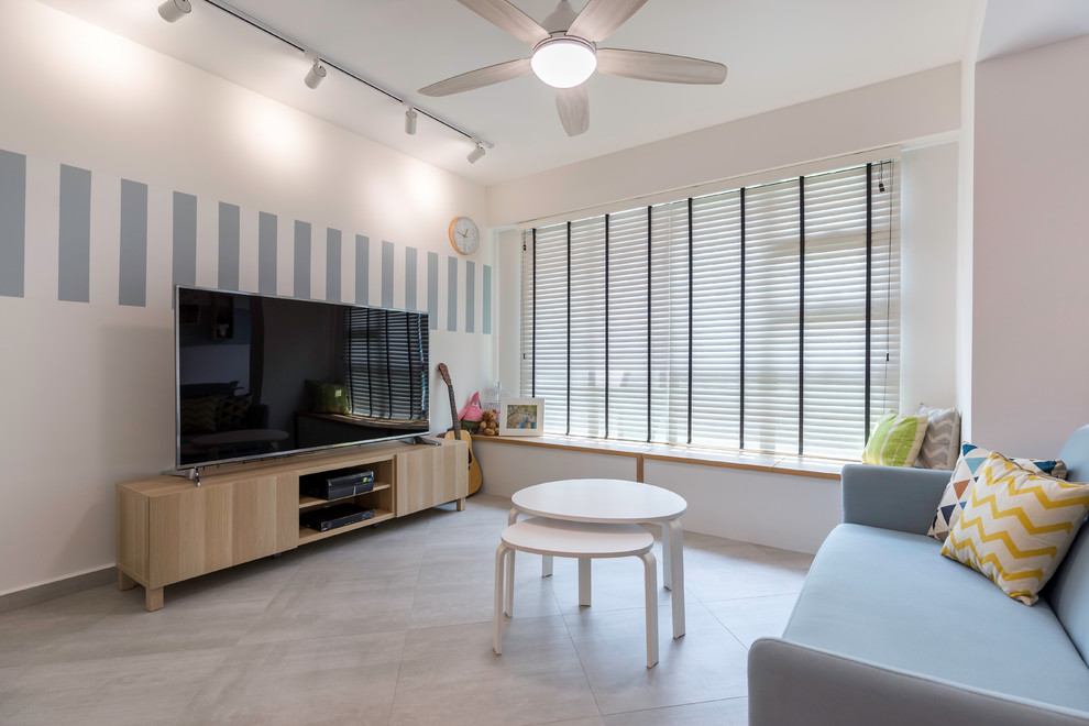 Пример оригинального дизайна: изолированная гостиная комната в скандинавском стиле с серыми стенами, отдельно стоящим телевизором и серым полом