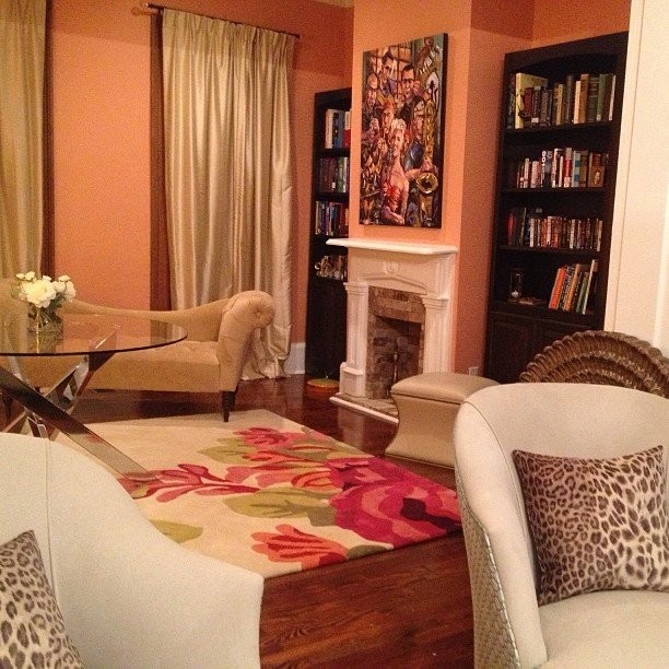 Eklektisk inredning av ett stort separat vardagsrum, med rosa väggar, mörkt trägolv och en standard öppen spis