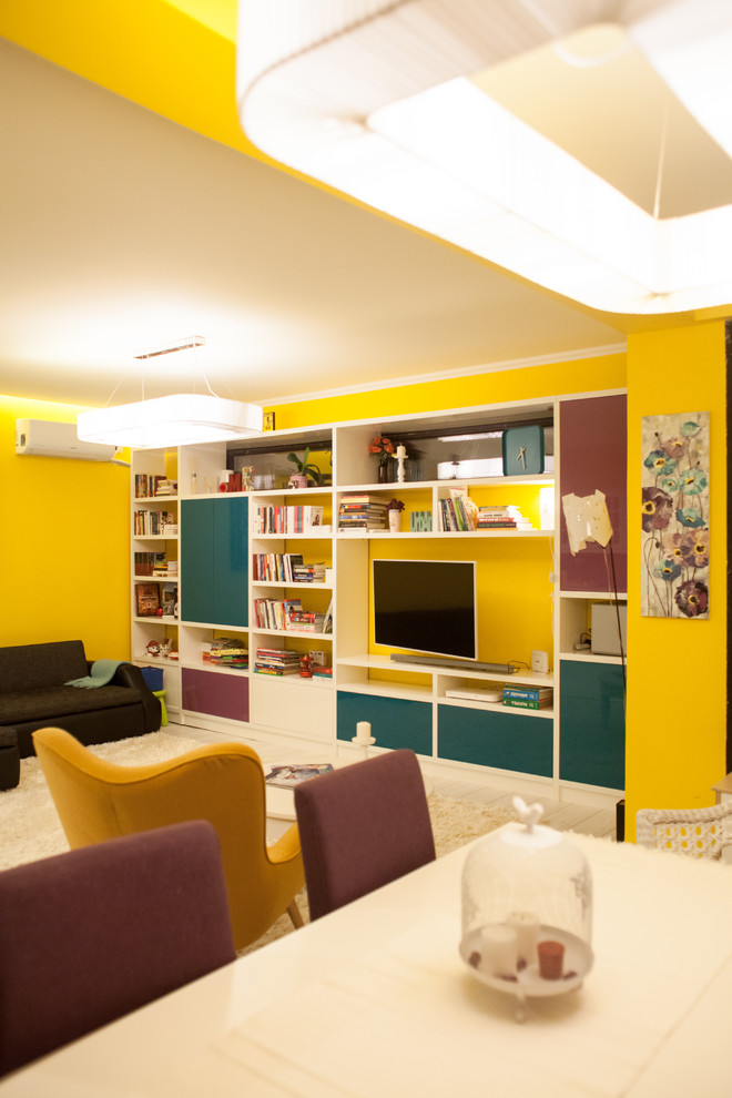 Foto på ett stort eklektiskt allrum med öppen planlösning, med gula väggar, ljust trägolv, en väggmonterad TV och vitt golv