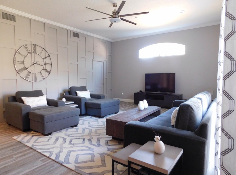 Exemple d'un salon chic de taille moyenne et ouvert avec une salle de réception, un mur gris, parquet clair, un téléviseur indépendant et un sol gris.