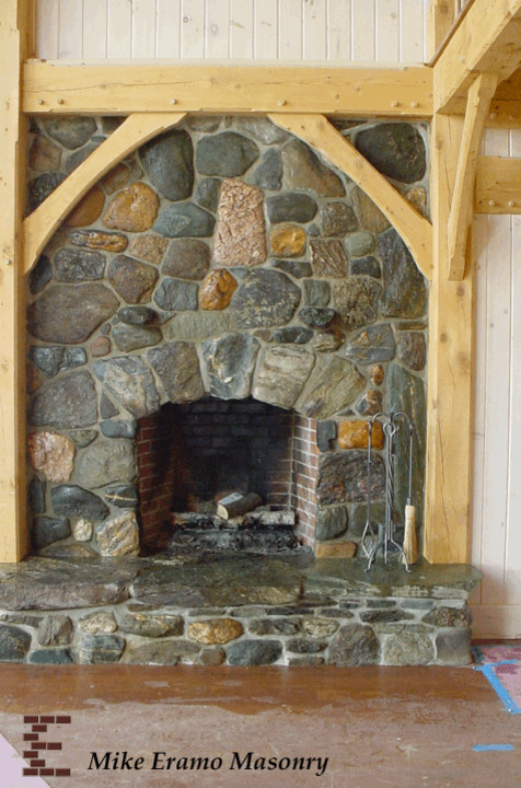 Imagen de salón rústico con todas las chimeneas y marco de chimenea de piedra