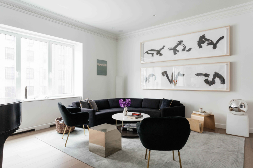 Cette photo montre un grand salon tendance ouvert avec un mur blanc, parquet clair et canapé noir.