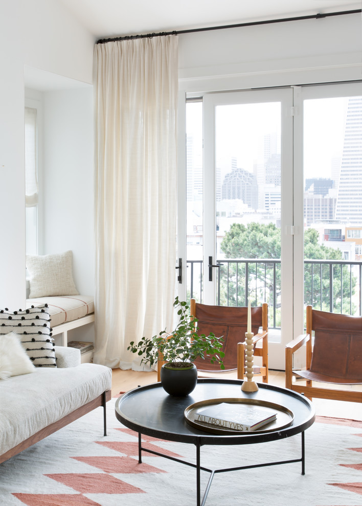 Example of a mid-sized danish formal and open concept light wood floor and brown floor living room design in San Francisco with white walls and no tv